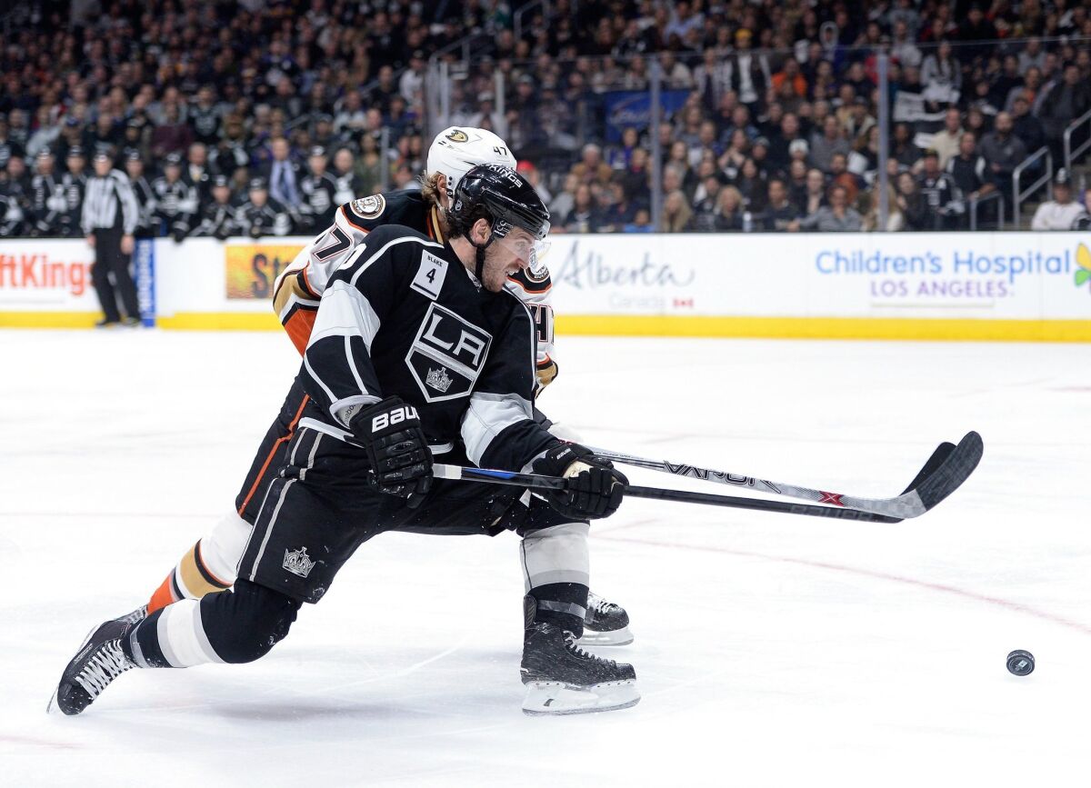 The Kings' Mike Richards attempts a backhand in front of the Ducks' Hampus Lindholm on Jan. 17 at Staples Center.