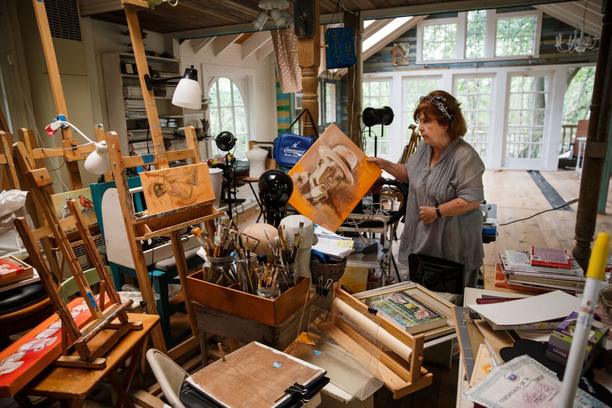 Sue Bown sorts through artwork damaged by Harvey floodwaters in her studio next to the Dickinson Bayou in Texas.