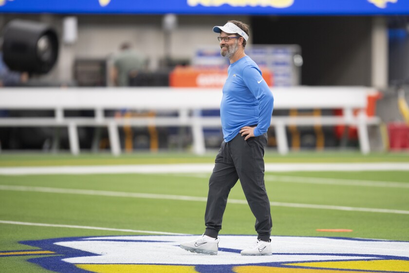 Chargers quarterbacks coach Shane Day walks the SoFi Stadium field before a preseason game.