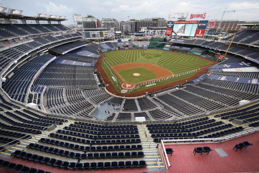 FILE - The New York Yankees and the Washington Nationals stand on the field before their opening day baseball game with no fans in the seats at Nationals Park in Washington, in this Thursday, July 23, 2020, file photo. Sports events held amid the coronavirus pandemic have become a whole different sort of spectacle when it comes to spectators. (AP Photo/Alex Brandon, File)