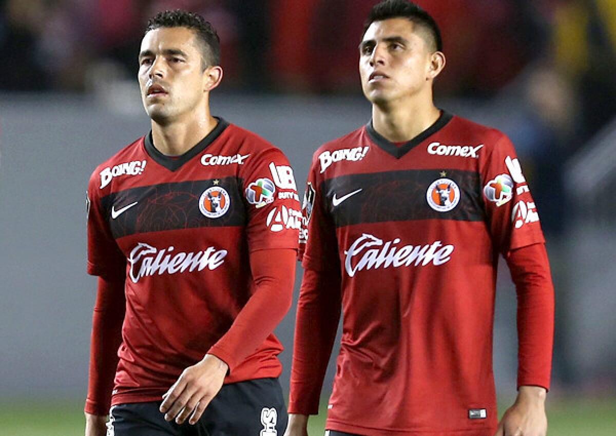 Xolos forward Herculez Gomez, left, and midfielder Joe Corona leave the field at StubHub Center after a 1-0 loss to the Galaxy in first game of a CONCACAF Champions League series that finishes Tuesday night in Tijuana.