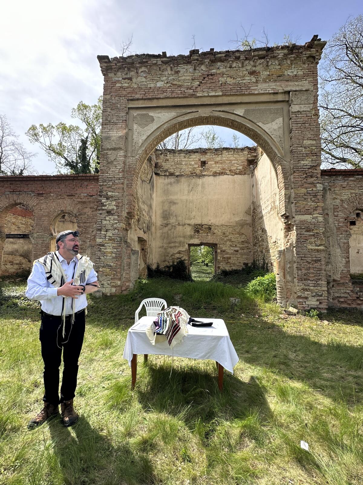 Rabbi David Kornberg standing outside the facade of the old chapel in Roudnice during the service.