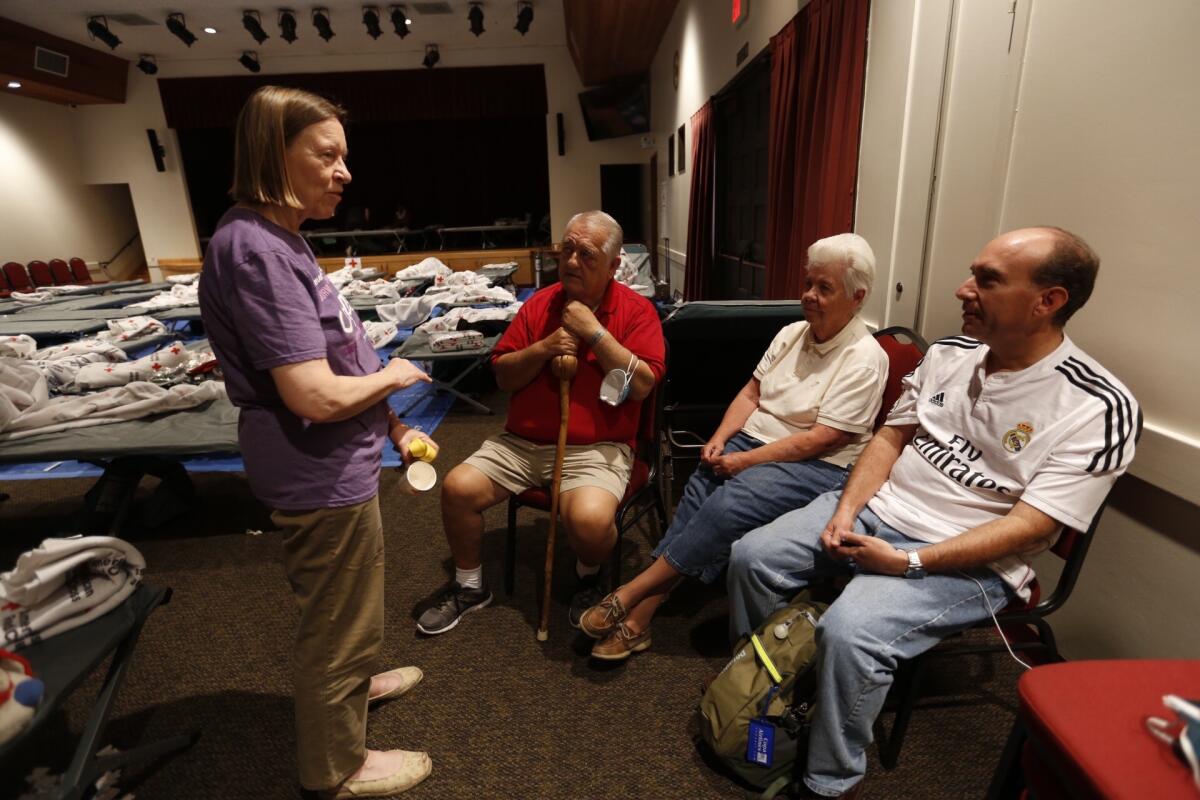 Liz Reilly, left, talks to fellow evacuees Richard Evans, wife Dorothy and son Richard J. Evans, all of whom spent the night in a Red Cross shelter in Duarte after being forced to flee their homes.