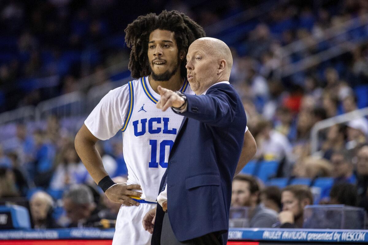 UCLA coach Mick Cronin talks to Tyger Campbell during a game.
