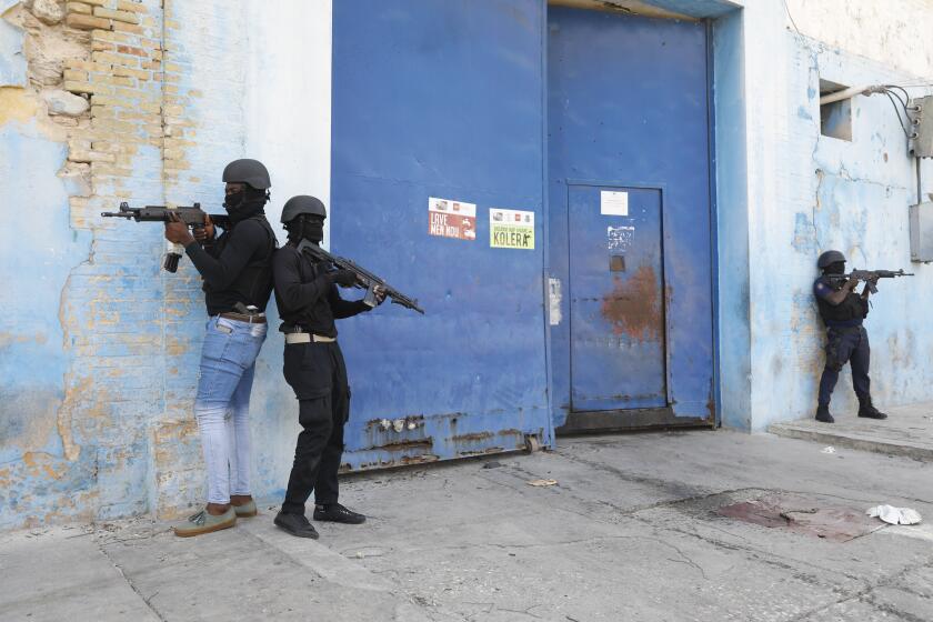Agentes de la Policía Nacional vigilan el exterior de la Penitenciaría Nacional, ya vacía tras una fuga de reos, luego que se registrara un pequeño incendio en las instalaciones, en el centro de Puerto Príncipe, Haití, el jueves 14 de marzo de 2024. (AP Foto/Odelyn Joseph)