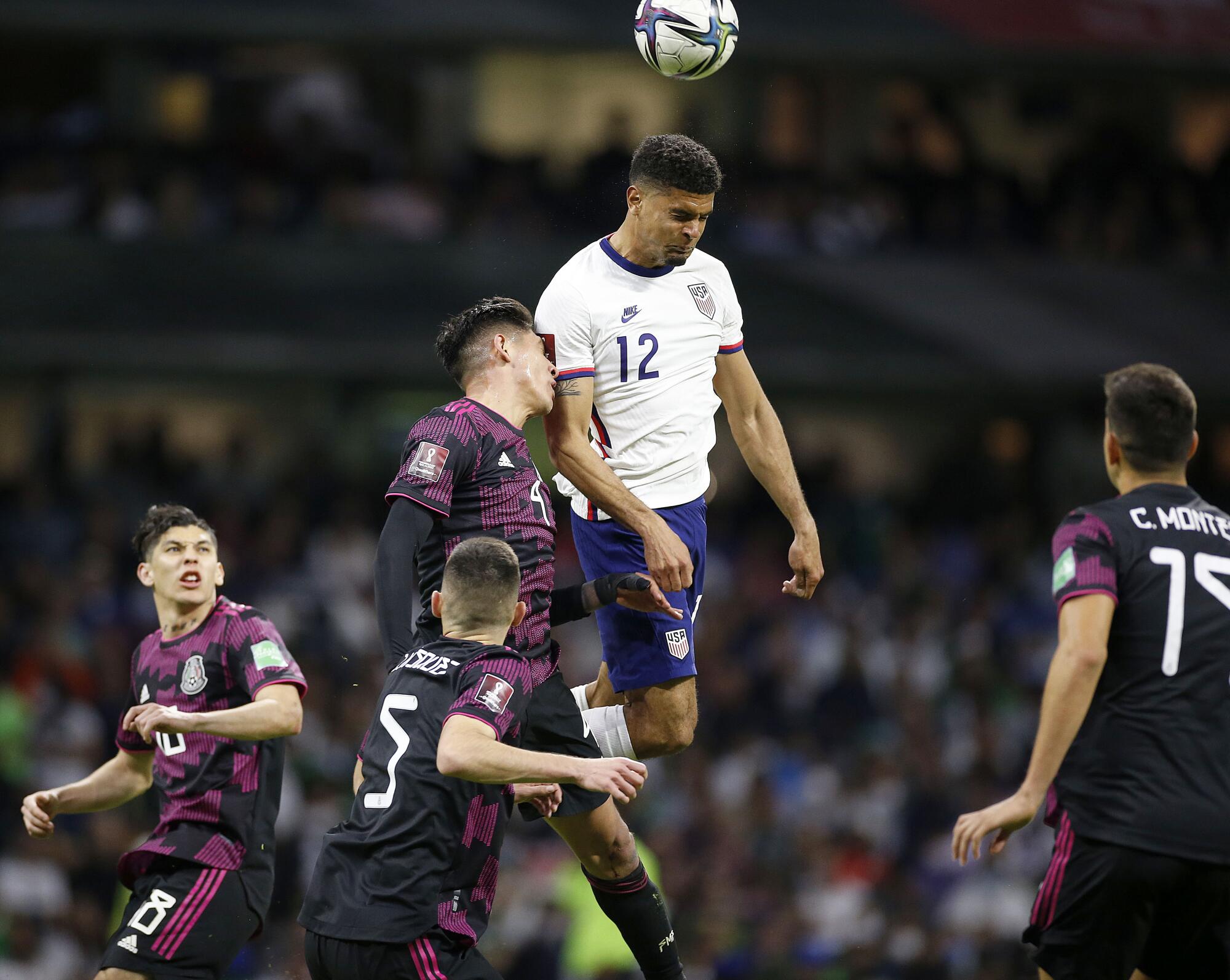 U.S. defender Miles Robinson, top, and Mexico defender Johan Vazquez and other Mexico players battle.