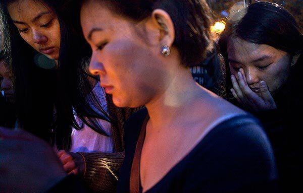 Shannon Cheng, center, and Nan Lin, right, mourn at a candlelight vigil Wednesday night. On Wednesday morning, two students were shot to death about a mile from campus.