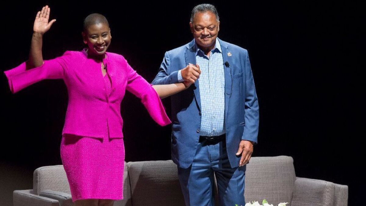 The Rev. Jesse Jackson greets the audience Friday with UC Irvine Professor Michele Goodwin during a presentation at UCI's Irvine Barclay Theatre.