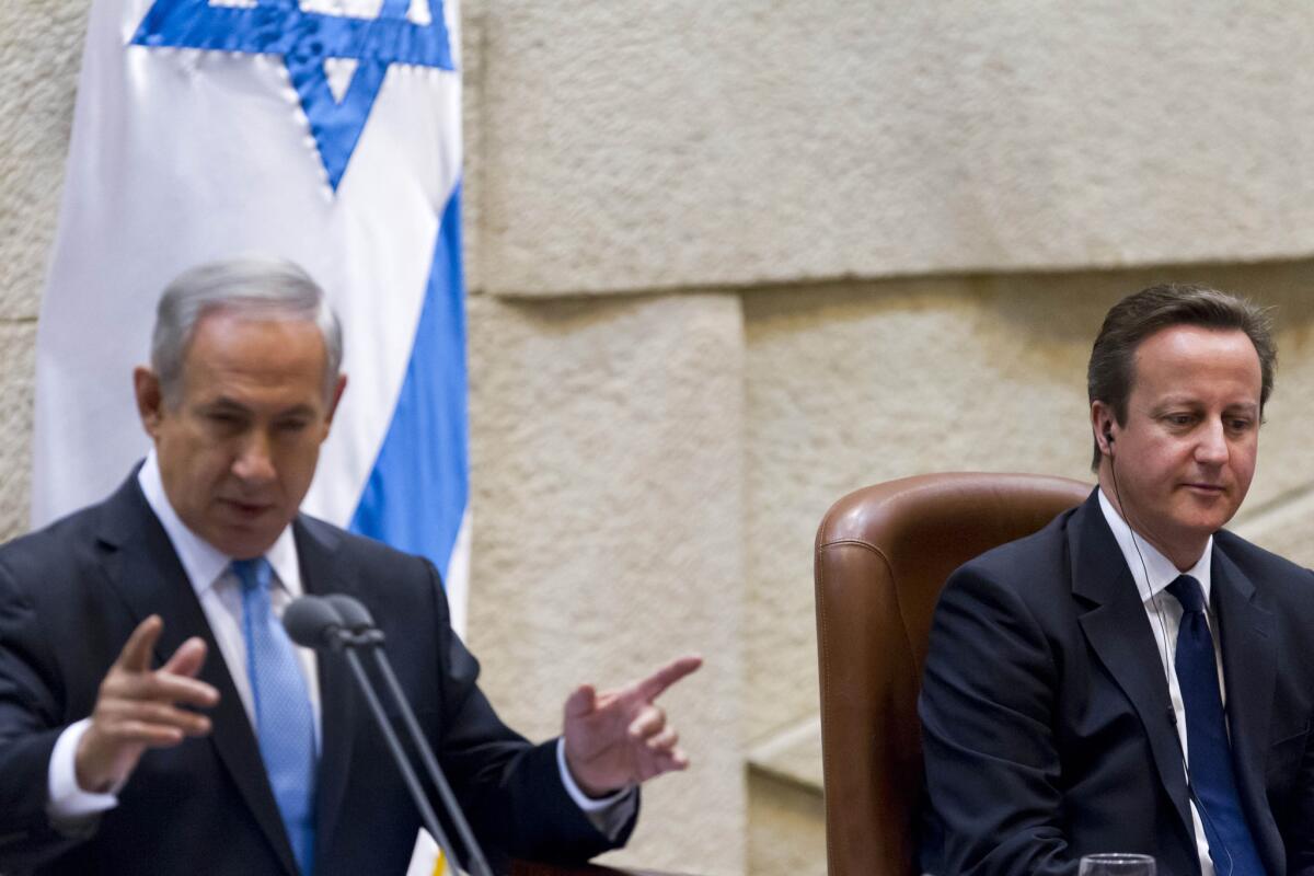 British Prime Minister David Cameron, right, listens to Israeli Prime Minister Benjamin Netanyahu as he addresses lawmakers in the Knesset in Jerusalem.