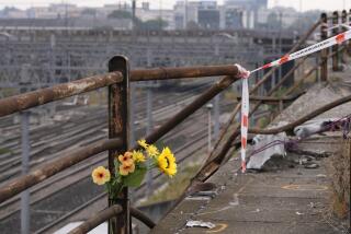 A bunch of plastic flowers is seen at the scene of a passenger bus accident in Mestre, near the city of Venice, Italy, Wednesday, Oct. 4, 2023. The bus fell from an elevated road, late Tuesday, killing multiple people. (AP Photo/Antonio Calanni)