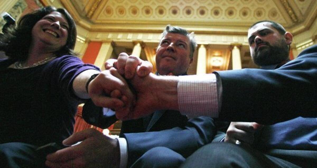 Leaders of Rhode Islanders United for Marriage clasp hands after vote to pass a gay marriage bill at the State House in Providence on Thursday.