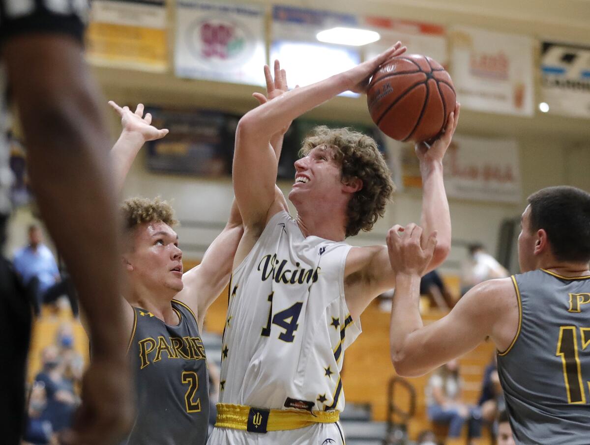 Marina's Bradley Fronek (14) drives into the paint and scores against Francis Parker's Camden McCormick on Tuesday night.