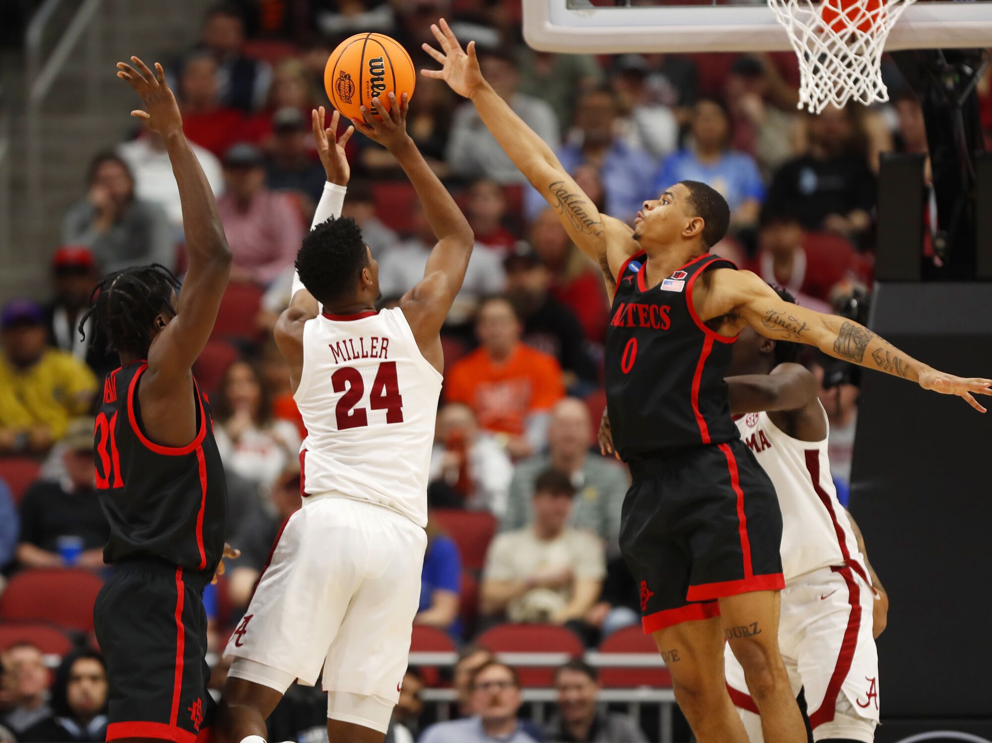 Nathan Mensah y Keshad Johnson, de San Diego State, defienden a Brandon Miller, de Alabama.