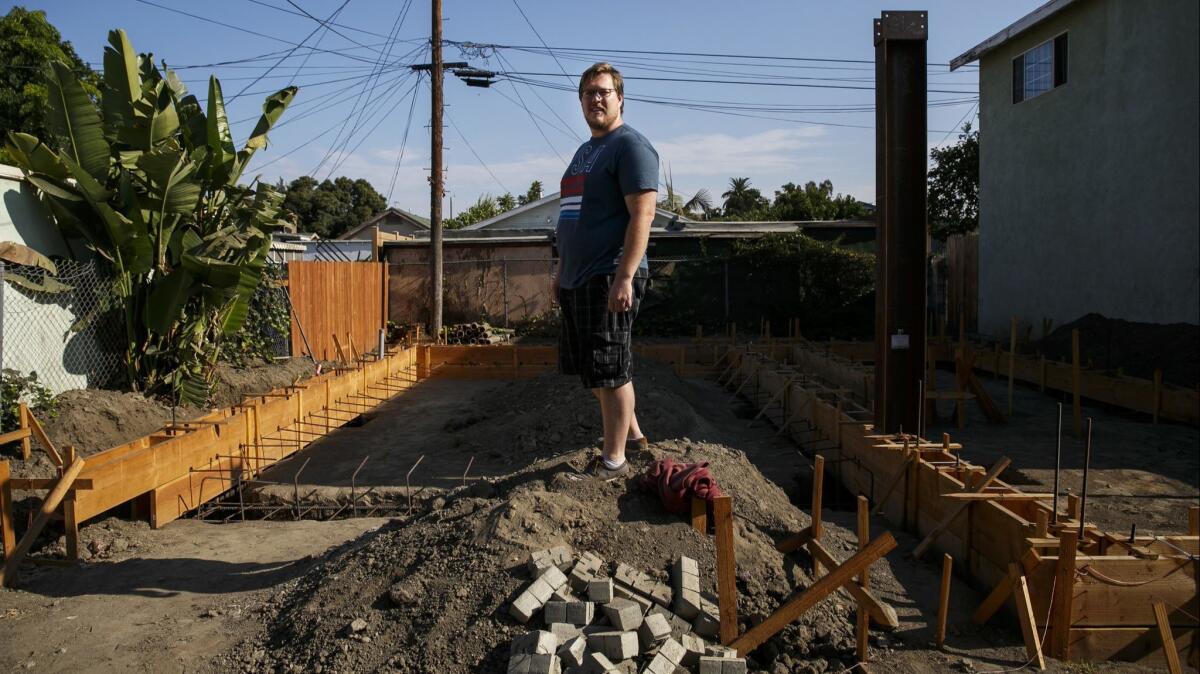 John Gregorchuk standing in the midst of an accessory dwelling unit construction that has been stalled in his backyard, in Los Angeles in August 2016.