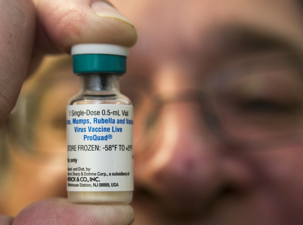 A pediatrician holds a dose of the measles-mumps-rubella vaccine at his practice in Northridge in 2015.