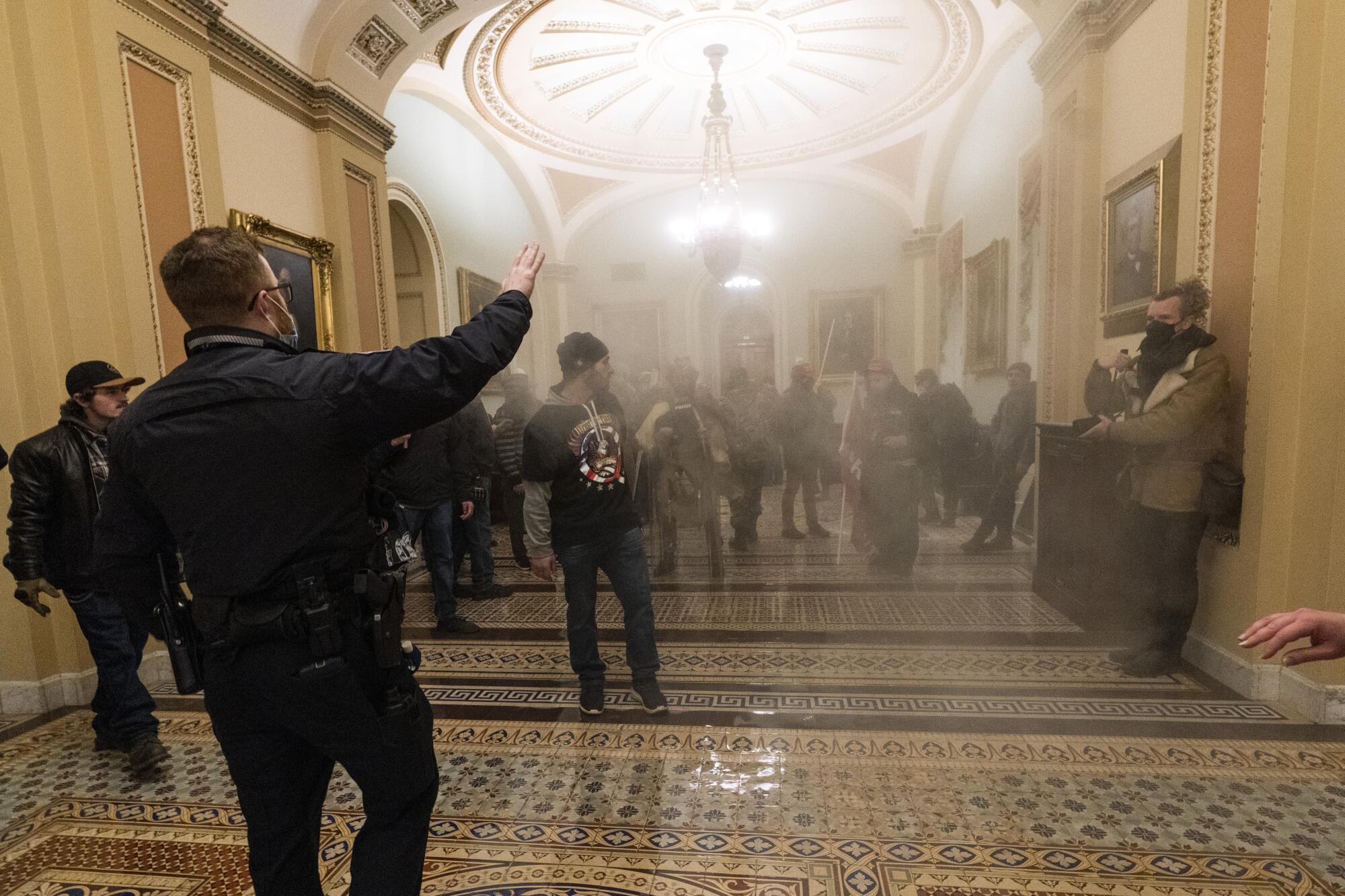 In this Jan. 6, 2021, file photo, smoke fills the walkway outside the Senate Chamber as