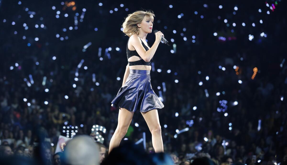 Taylor Swift on stage at Staples Center in Los Angeles on Aug. 21, 2015. Lights in the background are from cellphones and lighted wristbands Swift supplied to every member of the audience to more fully integrate fans into her concert.