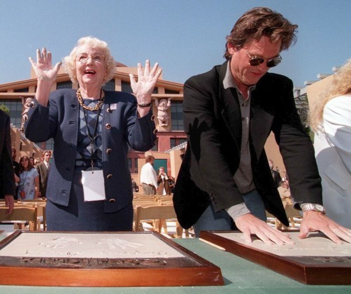 Virginia Davis and Kurt Russell make molds of their handprints as part of Disney's 75th anniversary celebration in 1998.