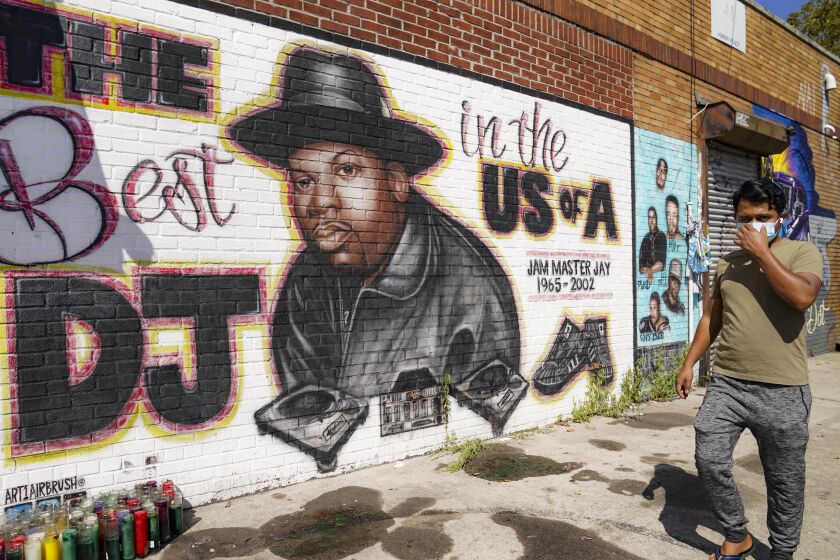 FILE - A pedestrian passes a mural of rap pioneer Jam Master Jay of Run-DMC, by artist Art1Airbrush, Aug. 18, 2020, in the Queens borough of New York. A third man has been charged in the 2002 shooting death of hip-hop trailblazer Jam Master Jay, prosecutors said Tuesday, May 30, 2023, adding another suspect in the Run-DMC member's killing which for years after it initially happened had languished as a cold case. (AP Photo/John Minchillo, File)