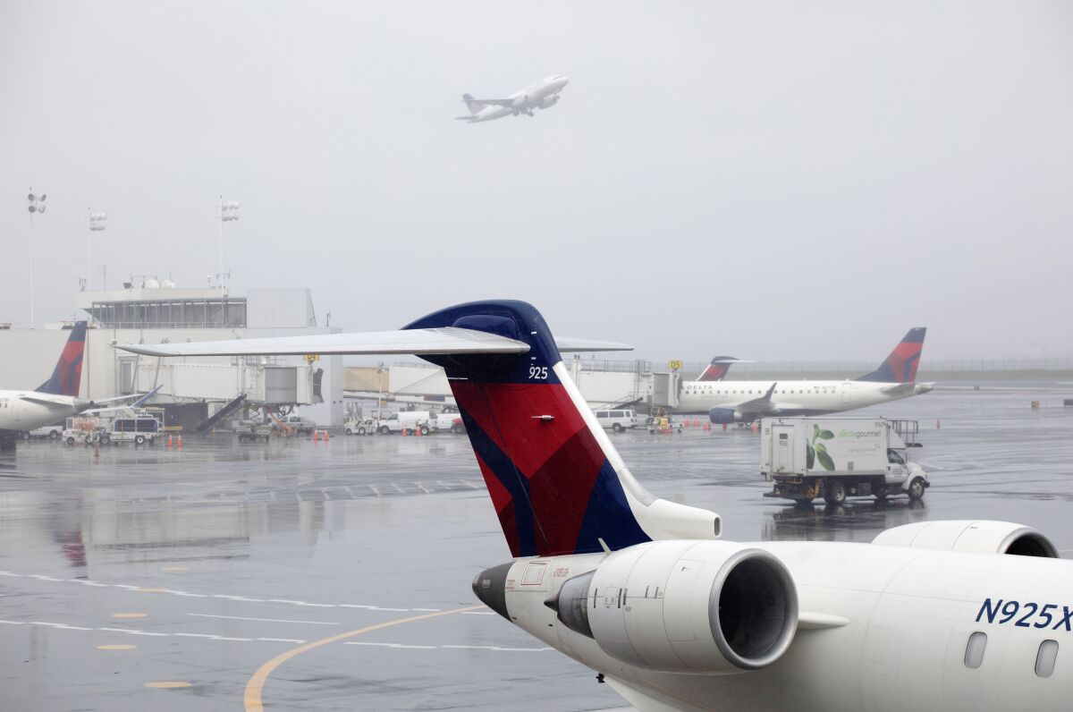 FILE - In this Oct. 29, 2019, file photo Delta planes are parked at the new $3.9 billion Terminal C at LaGuardia Airport in New York. Delta Air Lines said Friday, Feb. 14, 2020, that it will invest $1 billion over the next 10 years in measures designed to offset climate-warming carbon emissions from its planes. (AP Photo/Mark Lennihan, File)