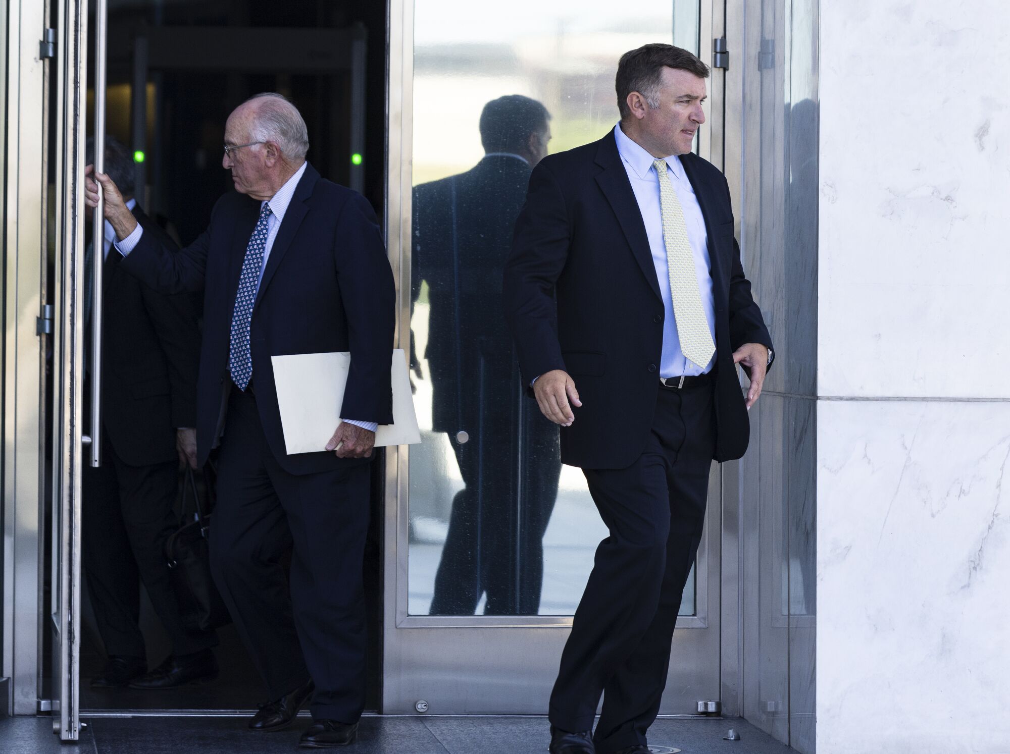 Two men leave a courthouse.