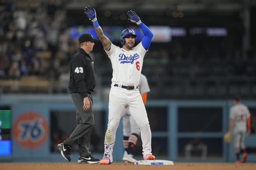 Dodgers' David Peralta celebrates with his arms in the air after hitting a double against the Detroit Tigers.