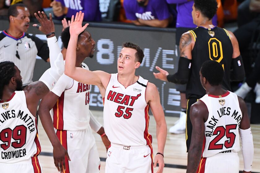 ORLANDO, FLORIDA OCTOBER 9, 2020-Heat's Duncan Robinson celebrates with Jae Crowder after his three-point basket and being fouled by Lakers Kyle Kuzma in Game 5 of the NBA FInals in Orlando Friday. (Wally Skalij/Los Angeles Times)