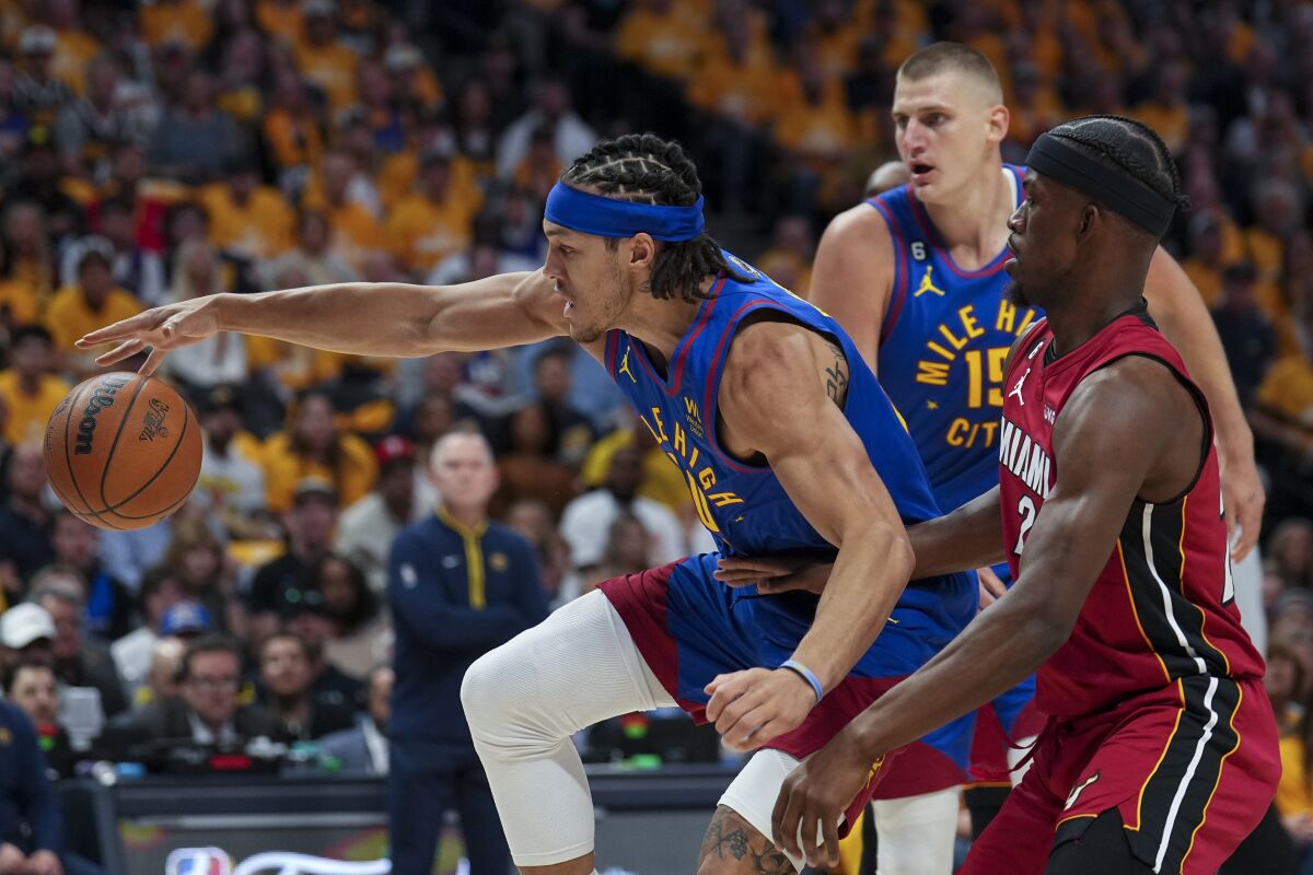 Denver Nuggets forward Aaron Gordon maintains possession of the ball while defended by Miami Heat forward Jimmy Butler.