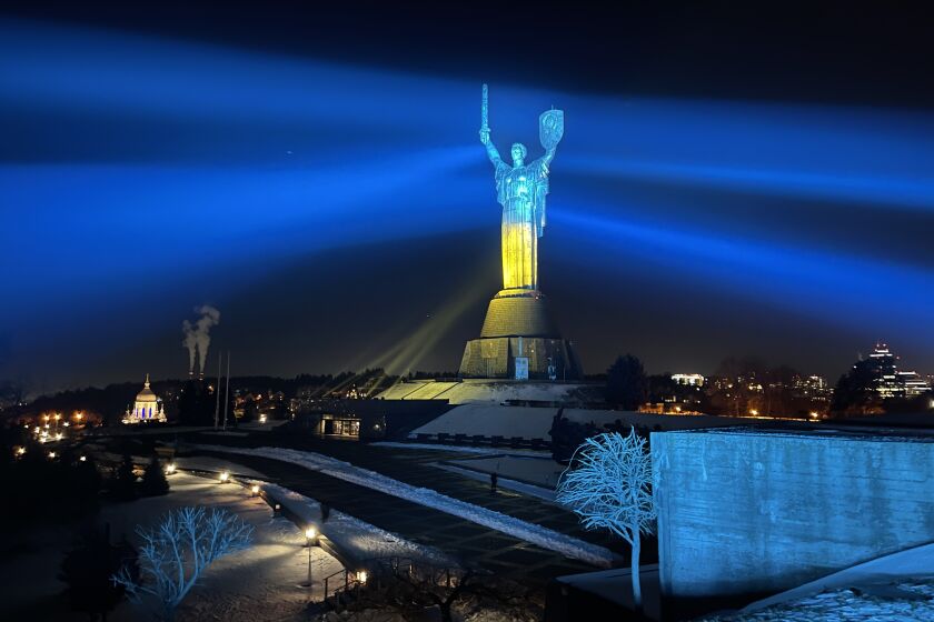 The Motherland Monument in Kyiv, lighted in the blue and yellow of the Ukrainian flag.