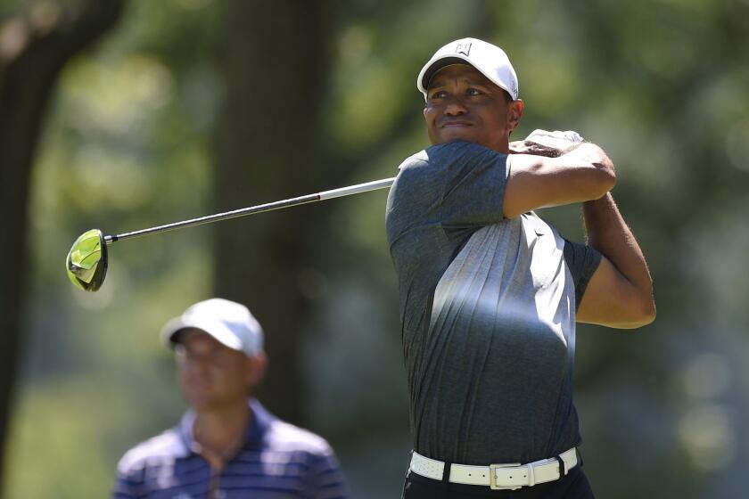 Tiger Woods watches his shot on the fifth tee during the second round of the Quicken Loans National golf tournament on Friday at the Robert Trent Jones Golf Club in Gainesville, Va.