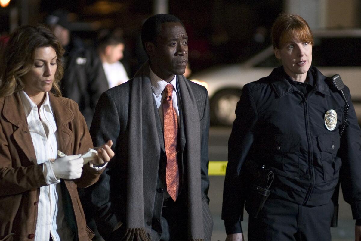 Jennifer Esposito, Don Cheadle and Kathleen York stand next to one another in a scene from “Crash”