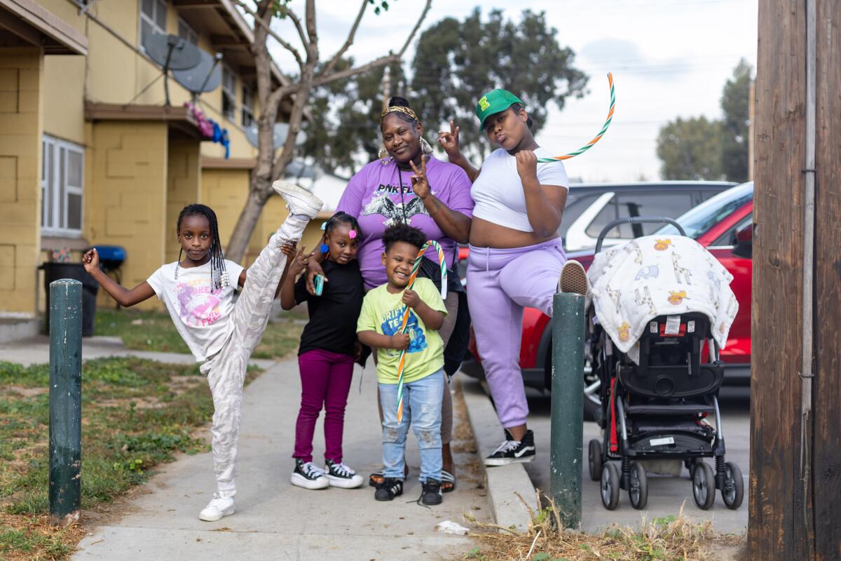 Eboni Childress, center, who's lived at Nickerson Gardens for 10 years, and her family await the start Tuesday of Top Dawg Entertainment's  annual toy drive and concert. 