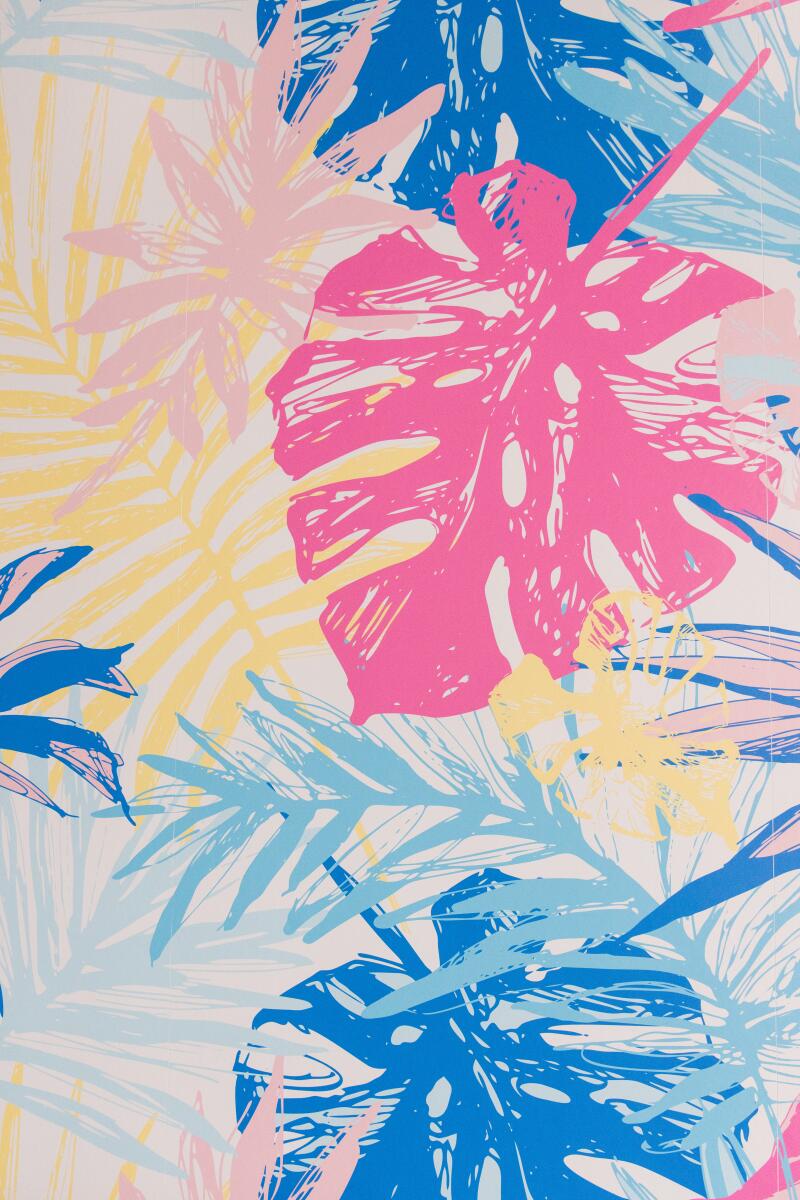 El Bacano's colorful wallpaper has monstera leaves and other tropical plants.