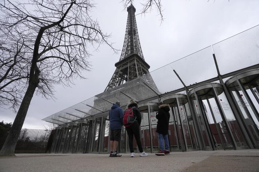 Visitors stand at the closed gates leading to the Eiffel Tower, Tuesday, Feb. 20, 2024 in Paris. Visitors to the Eiffel Tower were turned away for the second consecutive day because of a strike over poor financial management at one of the world's most-visited sites. (AP Photo/Michel Euler)