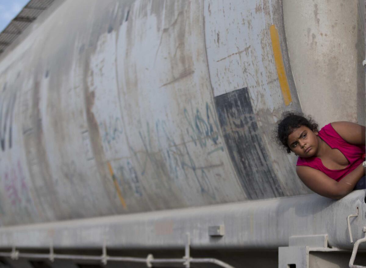 A young migrant girl waits for a freight train to depart on her way to the U.S. border, in Ixtepec, Mexico. White House officials say the flow of unaccompanied minors has begun to slow.