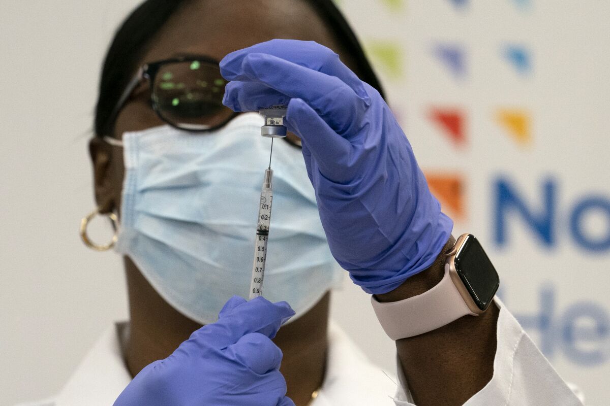 A doctor at a New York hospital draws the Pfizer-BioNTech COVID-19 vaccine into a syringe.  