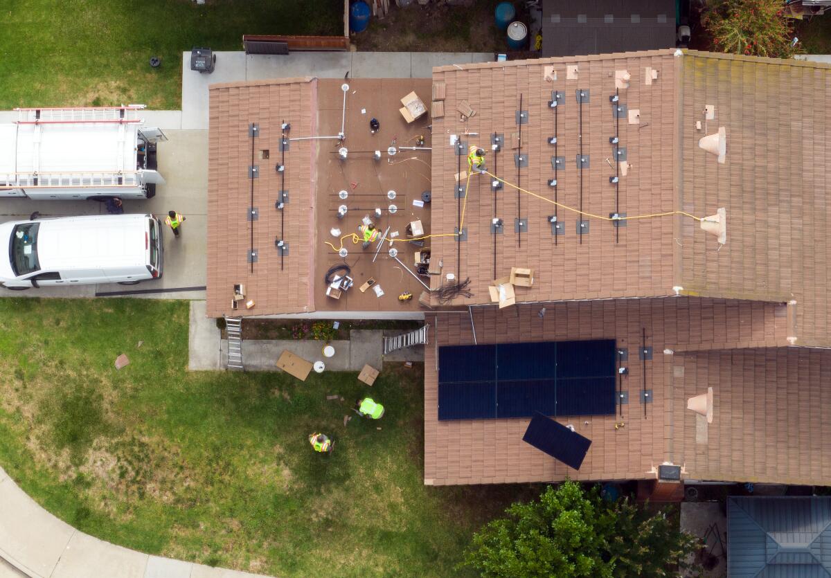 In an aerial view, a house gets solar panels installed.