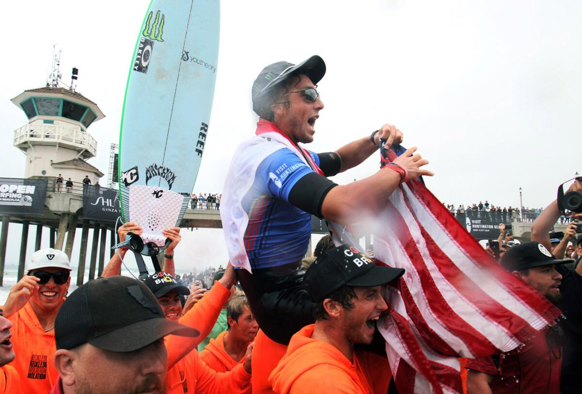 Griffin Colapinto is carried off the beach after winning the men's 2021 U.S. Open of Surfing on Sunday in Huntington Beach.