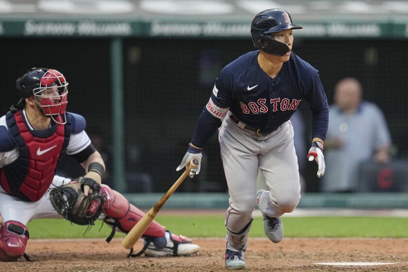 Boston Red Sox's Masataka Yoshida and Cleveland Guardians catcher Mike Zunino, left, watch Yoshida's double during the sixth inning of a baseball game Tuesday, June 6, 2023, in Cleveland. (AP Photo/Sue Ogrocki)