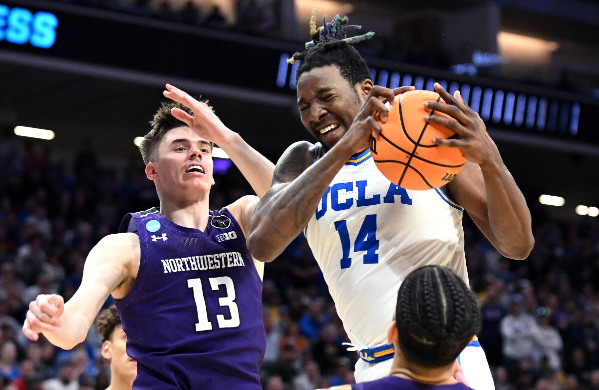 UCLA's Kenneth Nwuba grabs a rebound in front of Northwestern's Brooks Barnhizer.