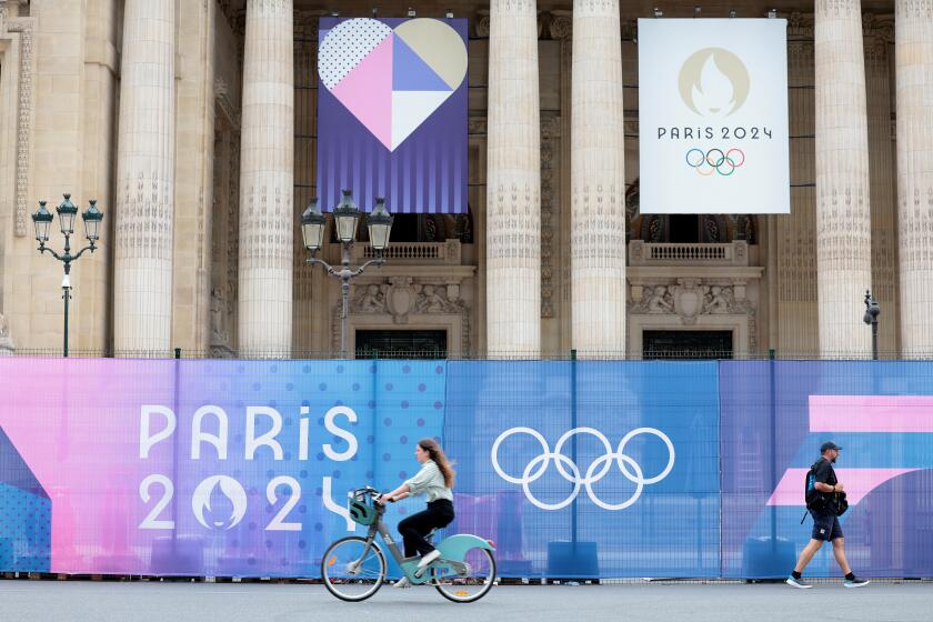 PARIS, FRANCE July 23, 2024-People ride and walk past the Grand Palais days before the Olympics in Paris, France Tuesday. Wally Skalij/Los Angeles Times)