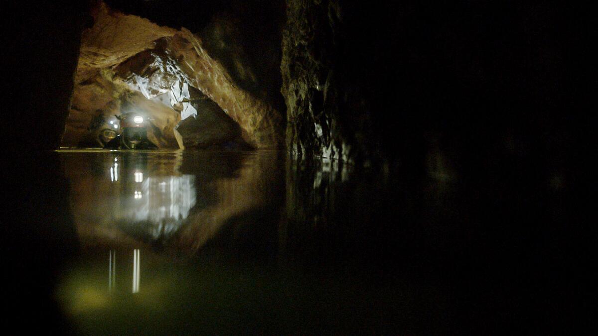 Two divers in a water-filled cave in a scene from "The Rescue."