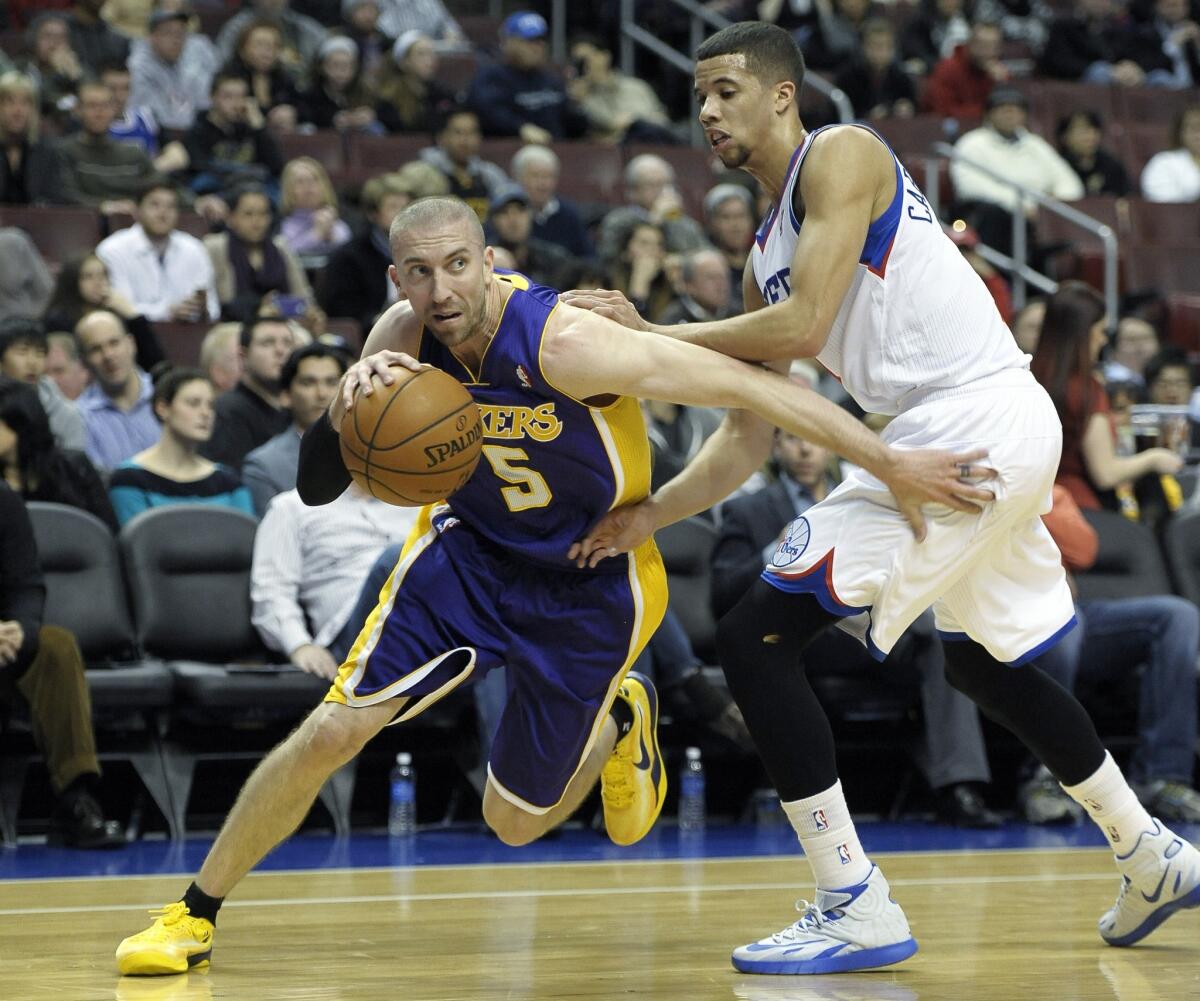 Lakers point guard Steve Blake drives past 76ers point guard Michael Carter-Williams in the first half.