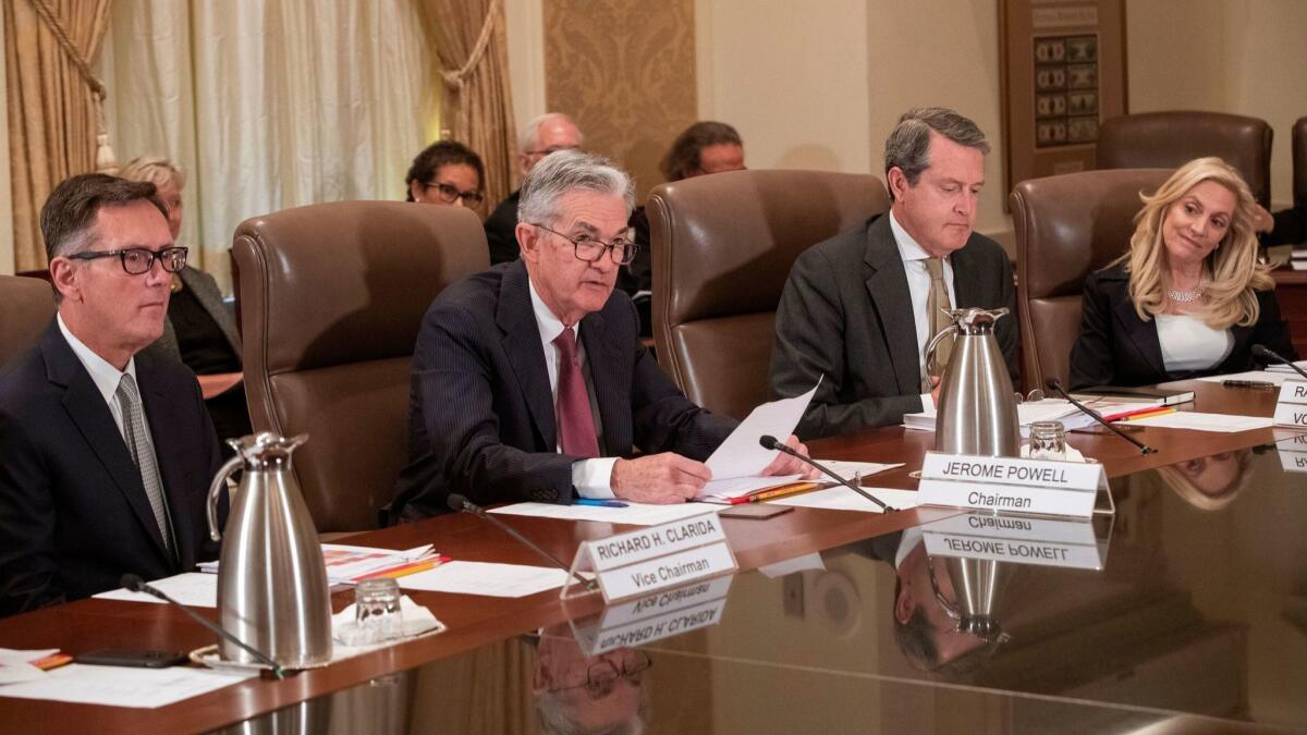 Members of the Federal Reserve Board of Governors, from left, Richard Clarida, Chairman Jerome H. Powell, Randal Quarles and Lael Brainard attend an open meeting on Oct. 31 in Washington.