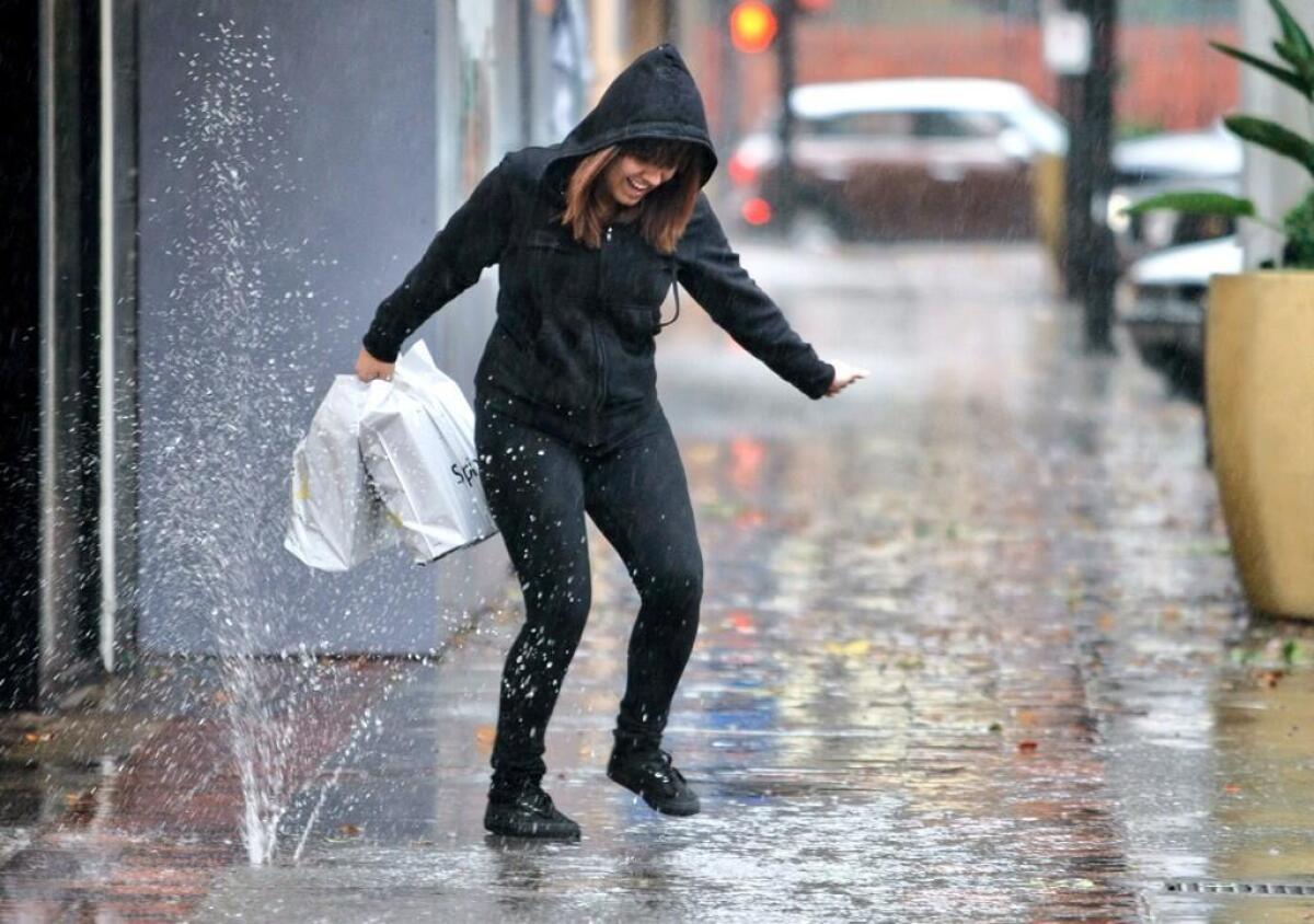 A woman avoids the rain on Brand Boulevard on Friday, Feb. 28.
