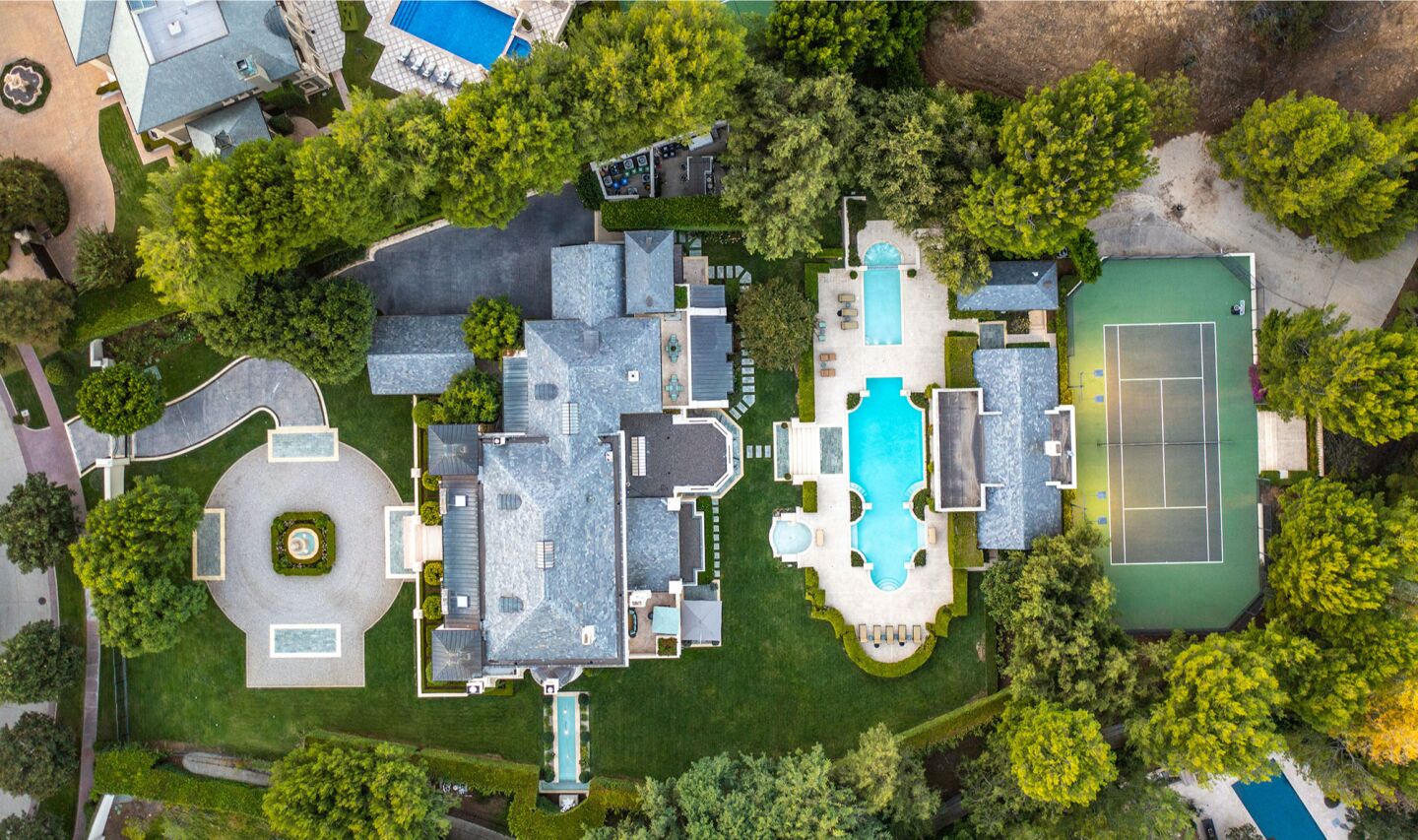 Aerial view of the estate showing the home, pool, tennis court and driveway.