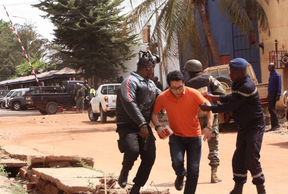 Mali troopers help a hostage leave the Radisson Blu hotel after gunmen attacked in Bamako, Mali, on Nov. 20.