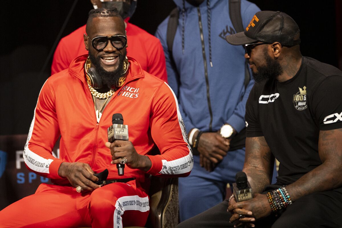 Deontay Wilder, left, speaks to his trainer, Malik Scott, during a news conference in advance of his heavyweight title boxing bout against Tyson Fury, in Las Vegas on Wednesday, Oct. 6, 2021. (Erik Verduzco/Las Vegas Review-Journal via AP)