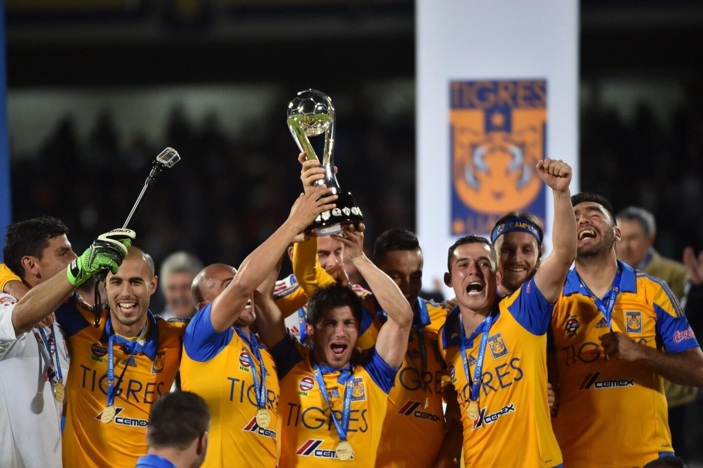 Tigres's footballers celebrate with the trophy after defeating Pumas during their Mexican Apertura tournament football final match at the Olimpic stadium on December 13, 2015 in Mexico City. AFP PHOTO/ Yuri CORTEZYURI CORTEZ/AFP/Getty Images ** OUTS - ELSENT, FPG, CM - OUTS * NM, PH, VA if sourced by CT, LA or MoD **