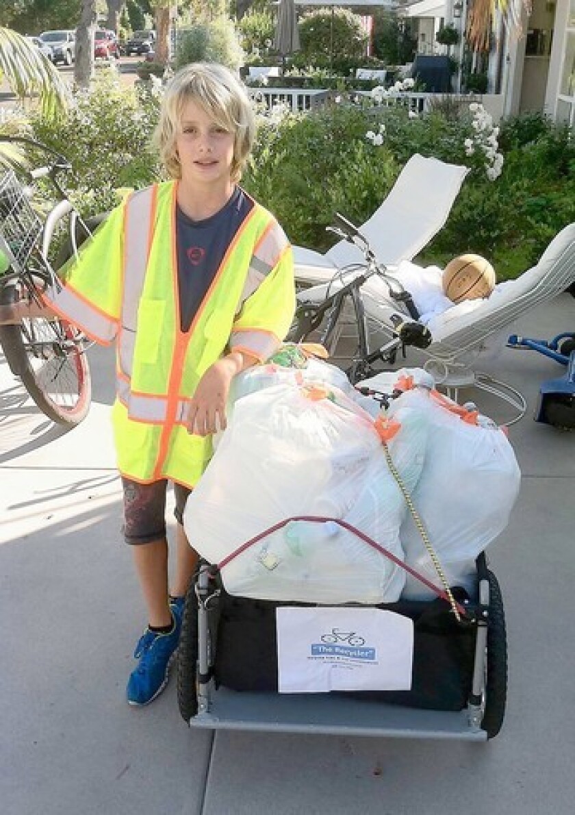 Harbor View student Vanis Buckholz with his trailer full of recyclables he pulls on his bike.
